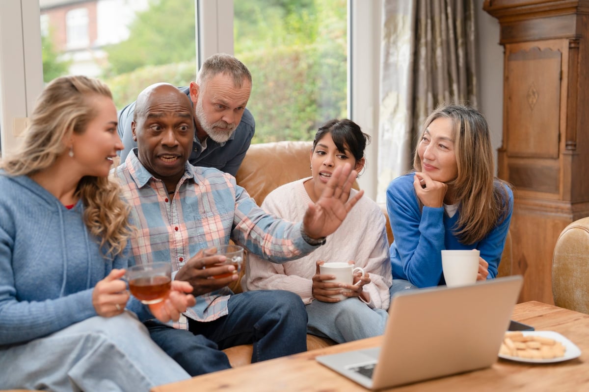 Residents sharing conversation over tea and coffee in a communal living room